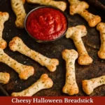 Cheesy Halloween breadstick bones served on a spooky plate for a Halloween party.